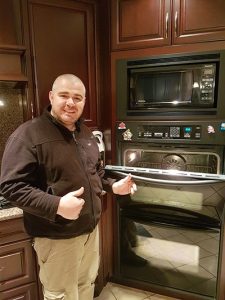 Max Appliance Repair technician beside a wall oven during a Halifax service visit